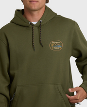 Load image into Gallery viewer, Person wearing a green hoodie with a logo on a light gray background
